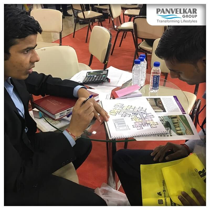 Two Men sitting with Floor Plan